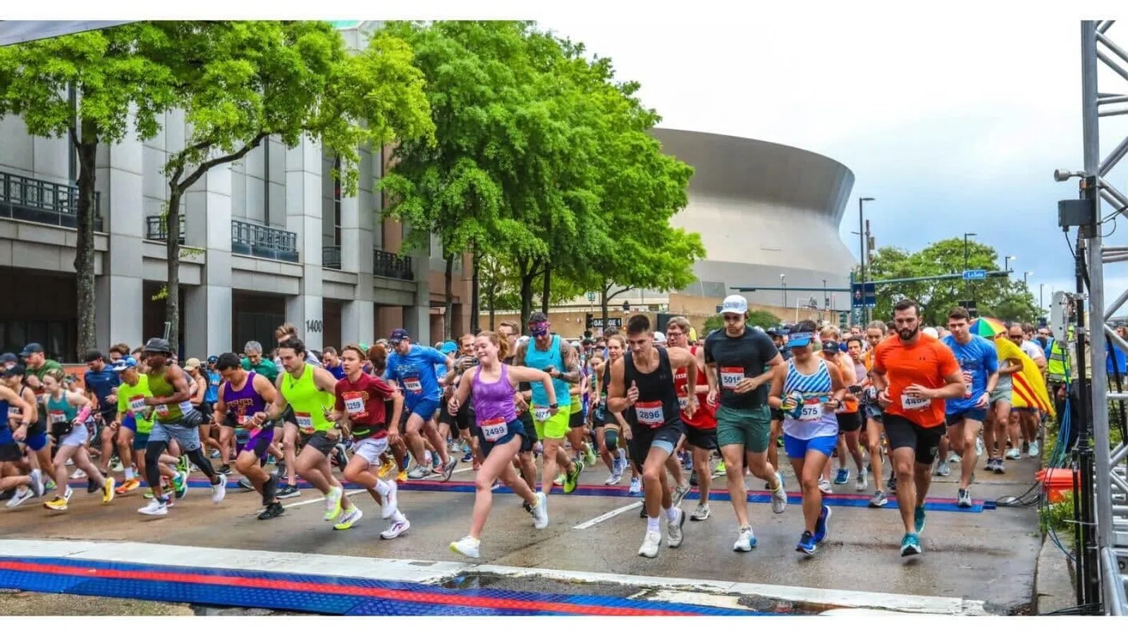 Runners starting the Crescent City Classic event, with branding and participant guide details.