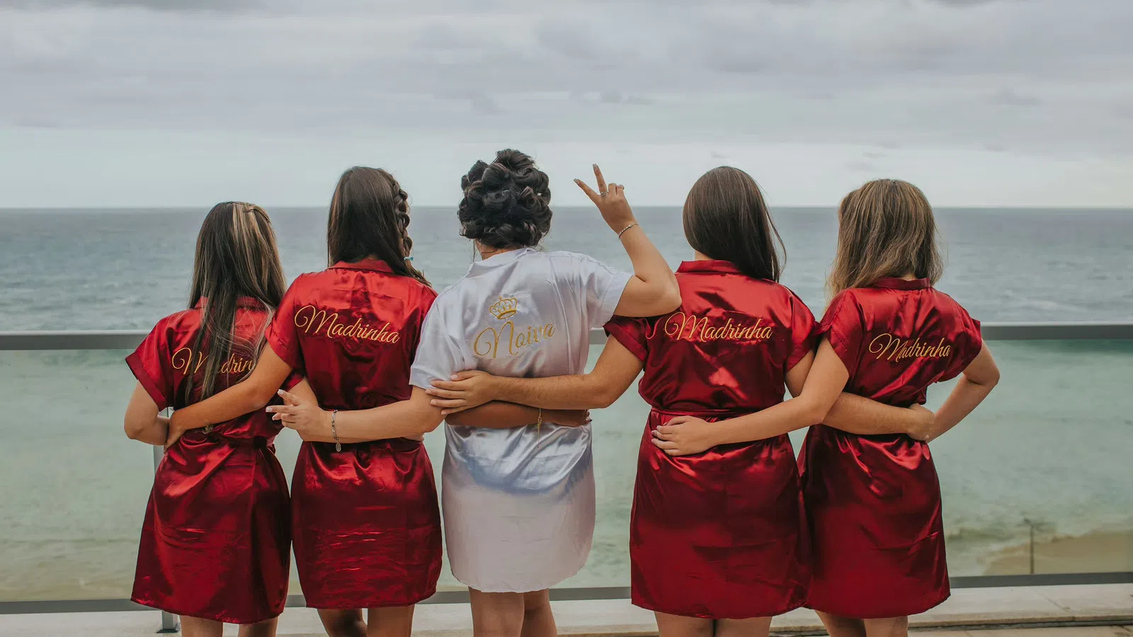 a group of women standing on a dock looking at the water