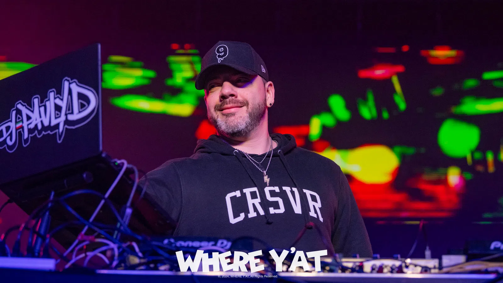 a man wearing a hat and a black shirt with a microphone