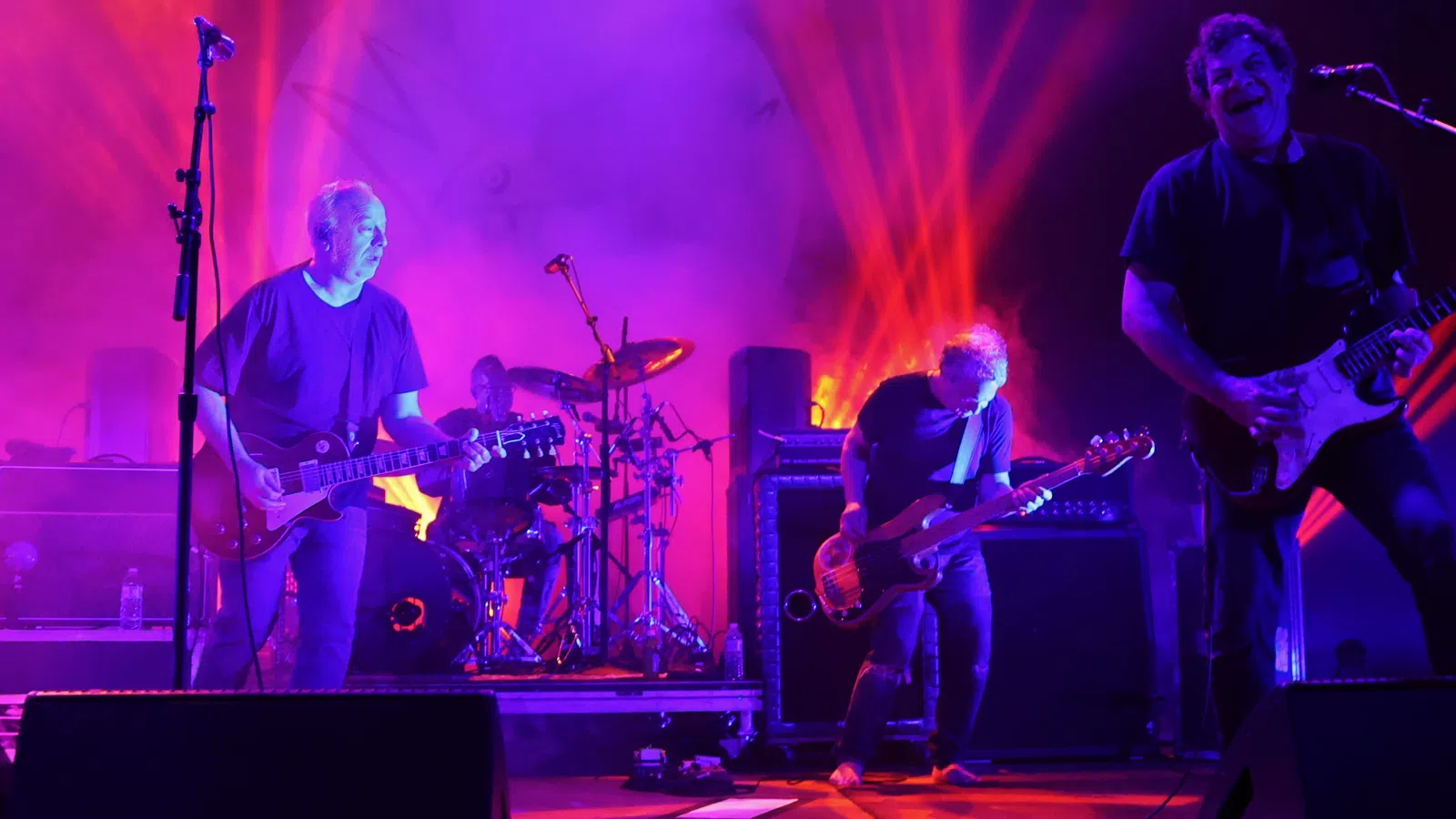a group of men playing guitars on a stage