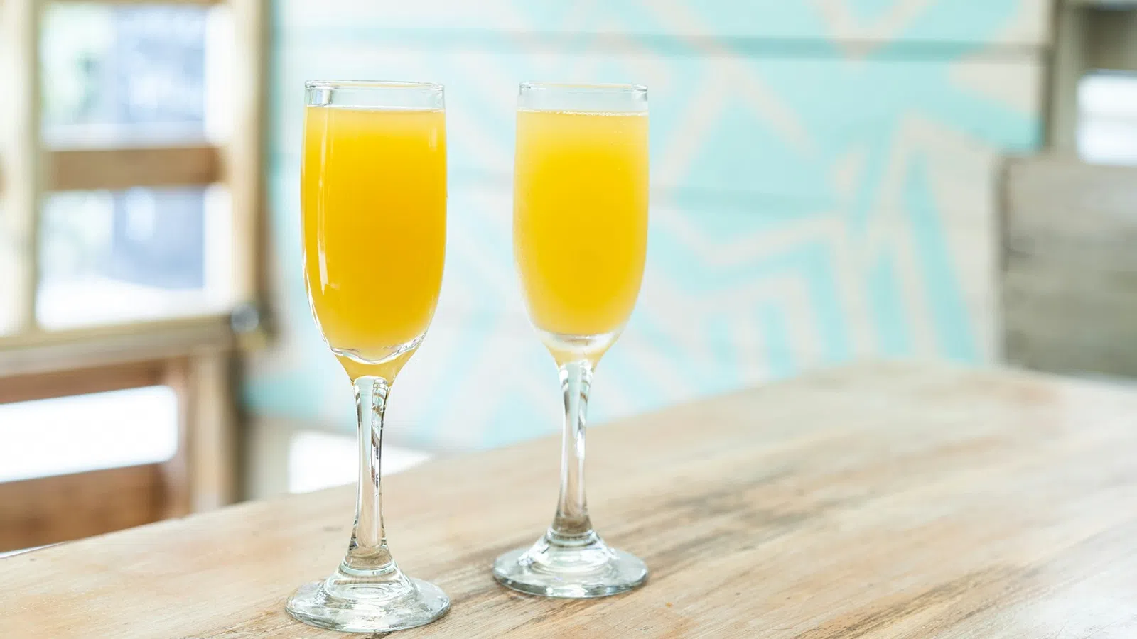 two glasses of orange juice on a table