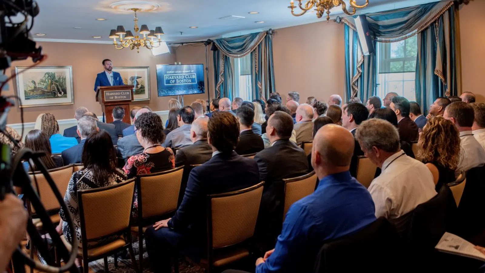 a group of people sitting and listening to a speech