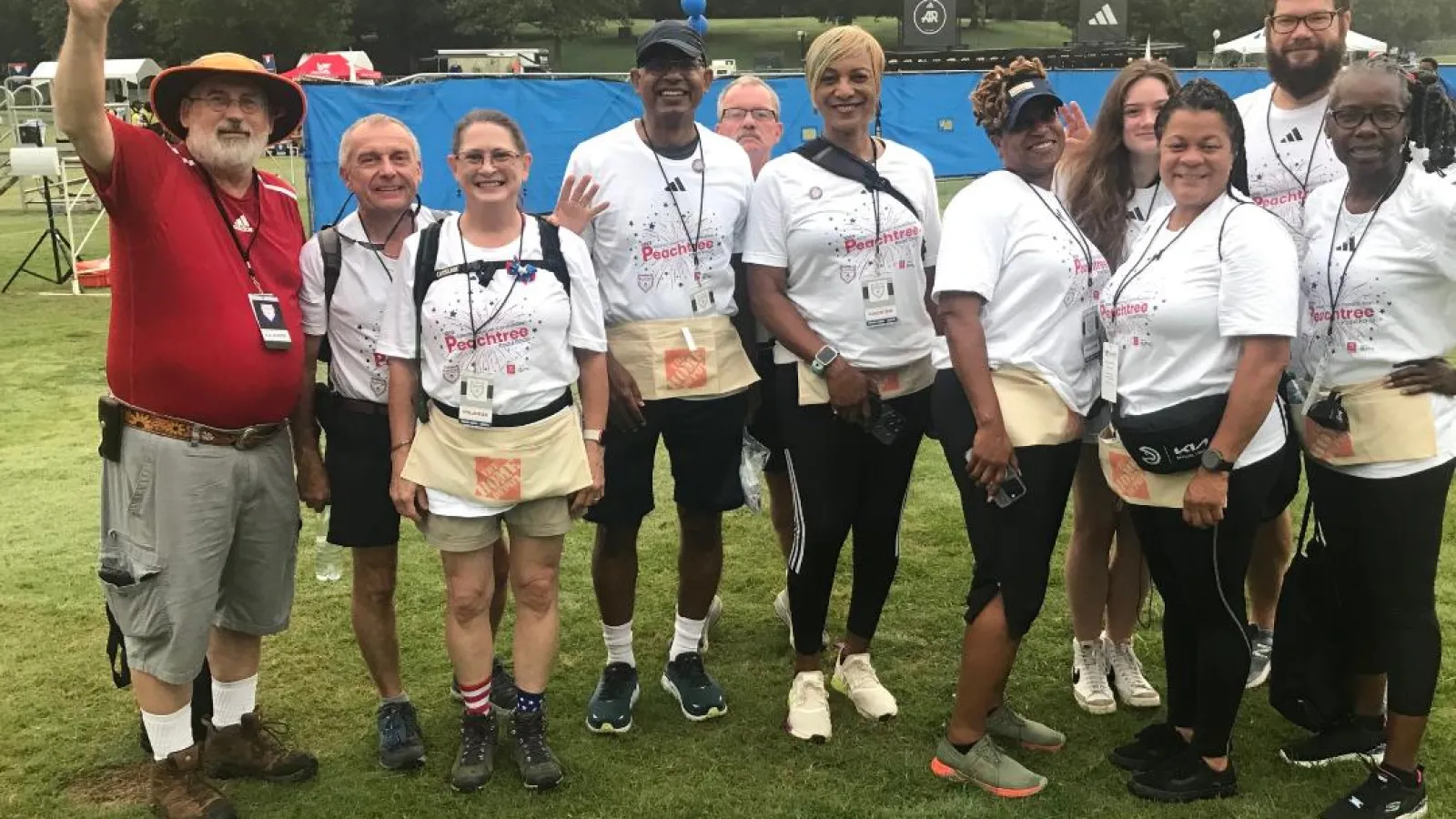 Group of volunteers smiling and posing at an outdoor event with colorful attire and accessories.