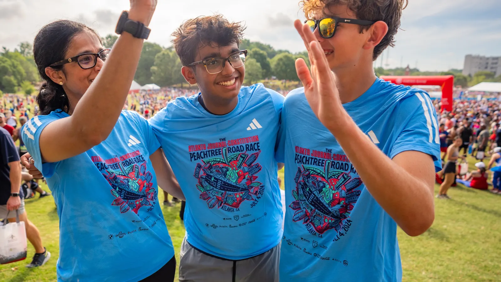 a group of people wearing matching t-shirts and holding their hands up
