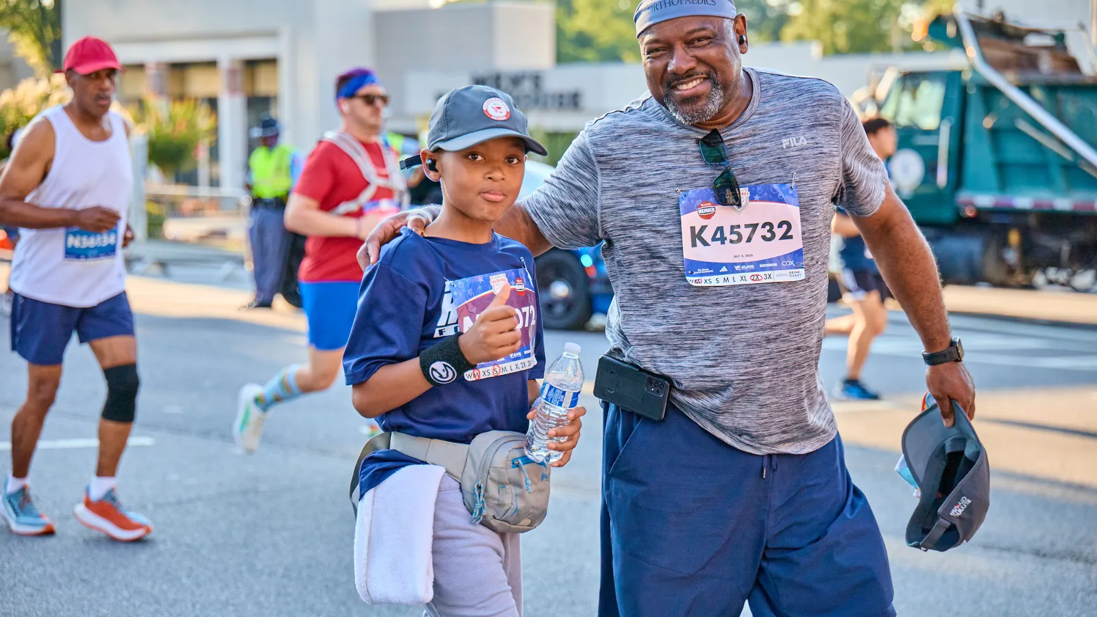 A father and son pose for a photo while running the Northside Hospital Peachtree Road Race