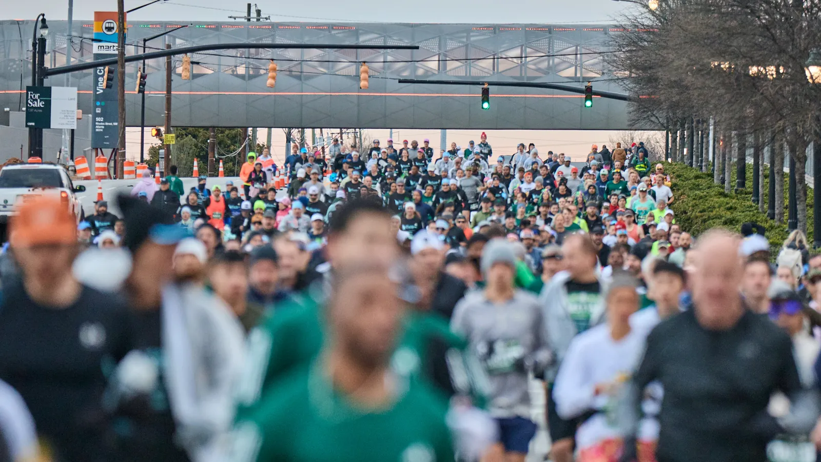 Large crowd of runners participating in an outdoor marathon or race event on a city street.