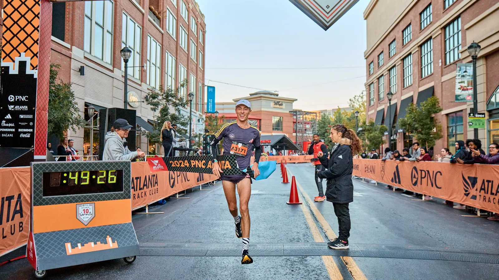 a group of people running on a street with signs and buildings