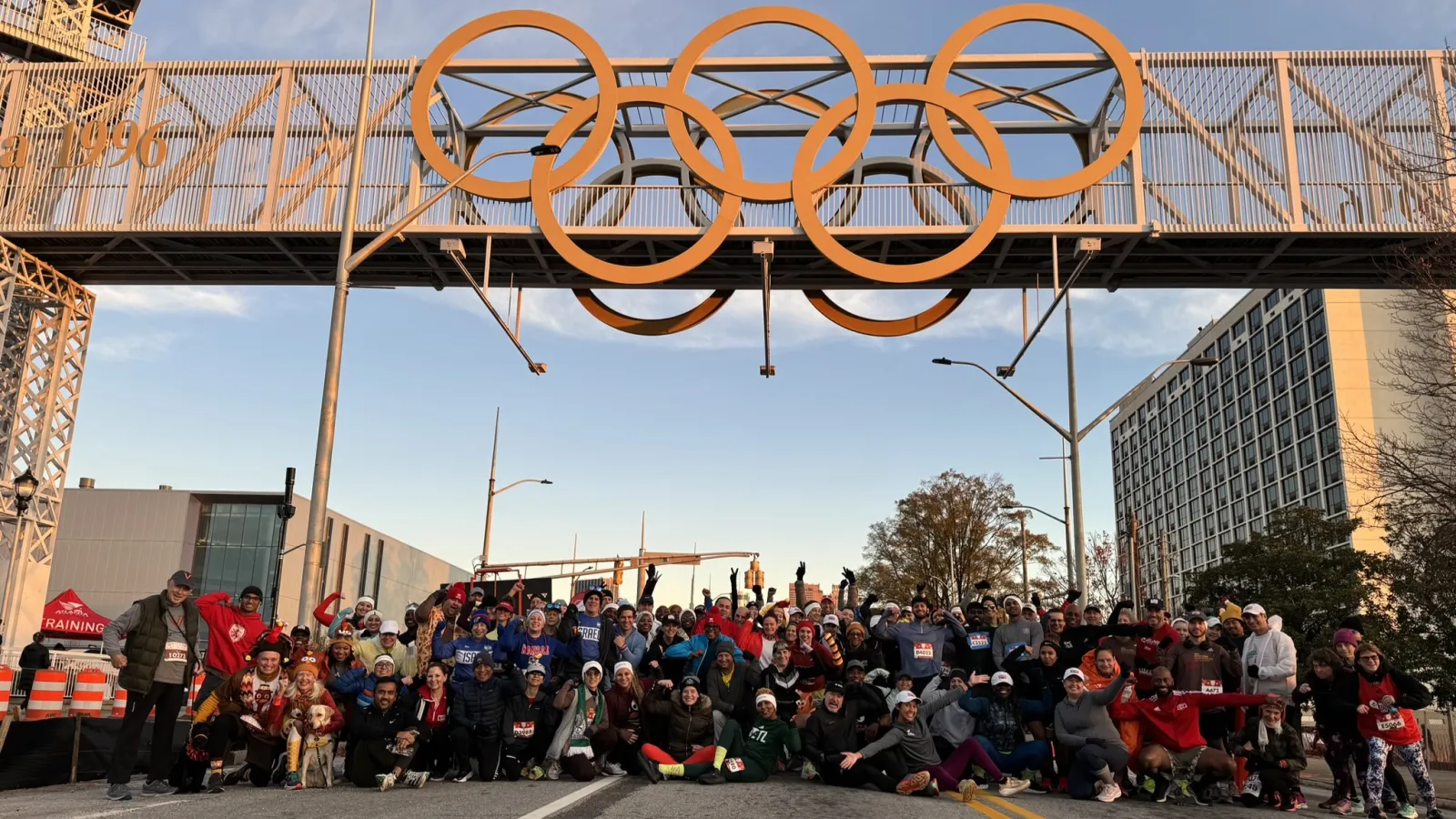 a group of people posing for a photo under a roller coaster