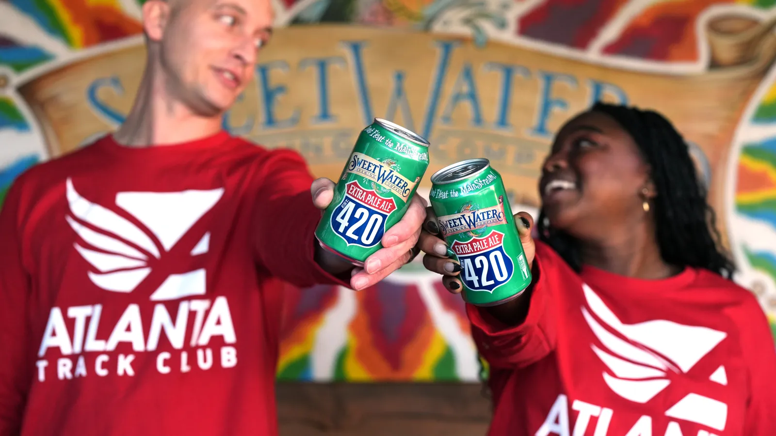 a man and woman holding cans