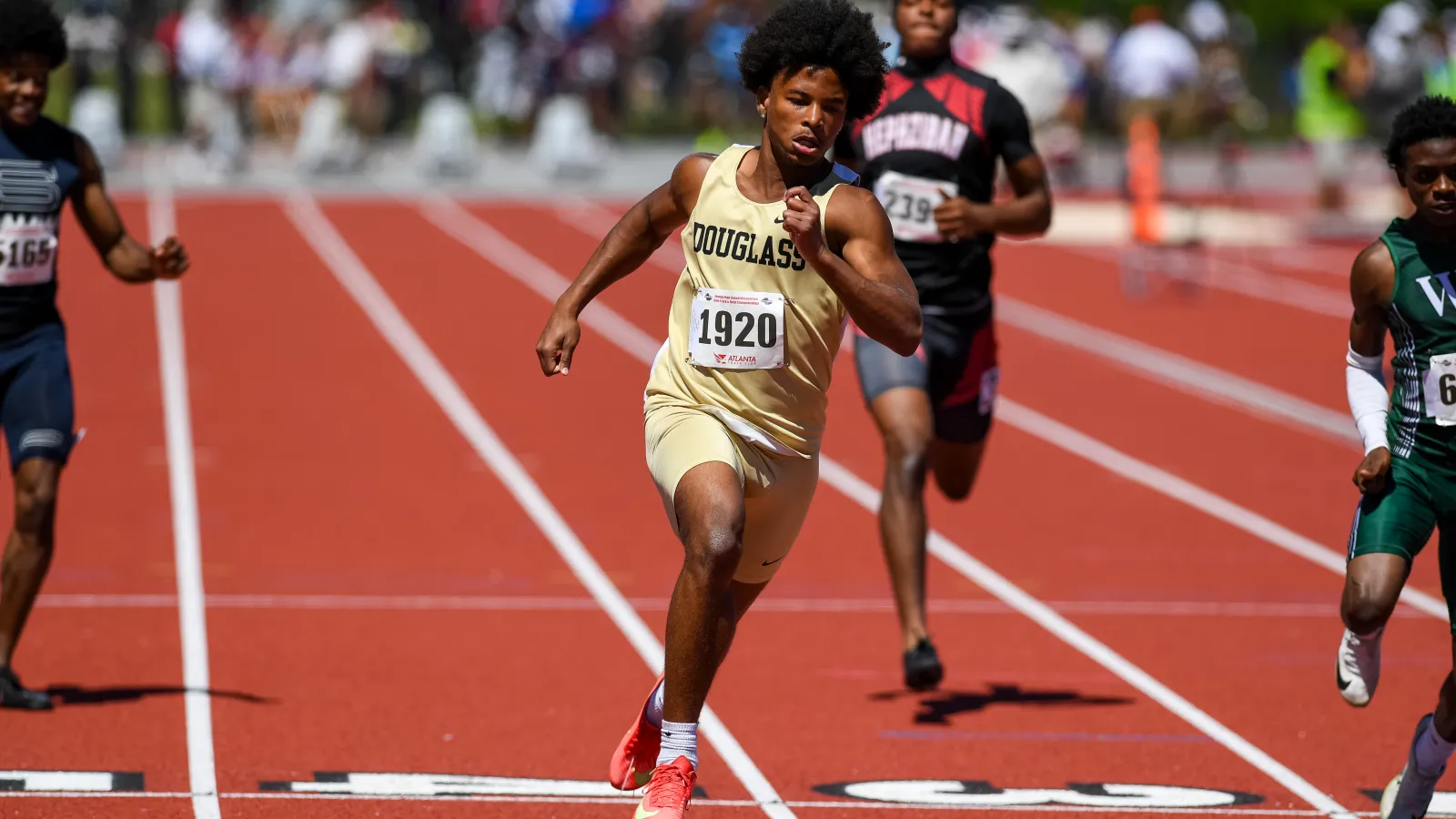Sprinter in beige Douglass uniform leads race on outdoor track with competitors in background