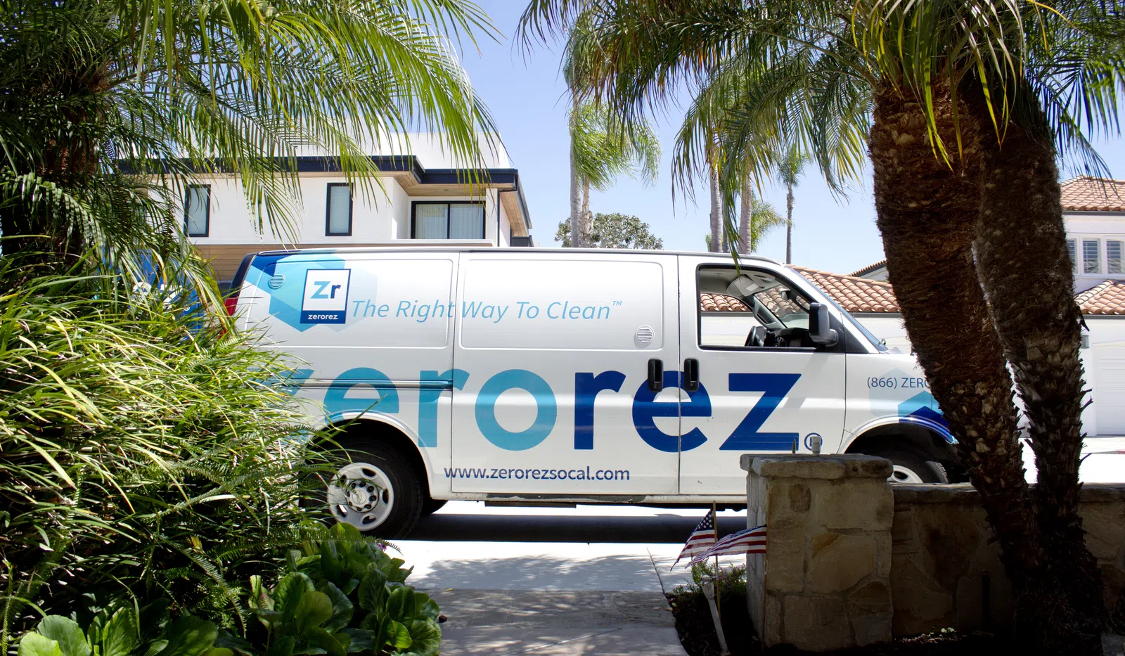 ZeroRez cleaning service van parked in a residential neighborhood with palm trees and houses in the background.