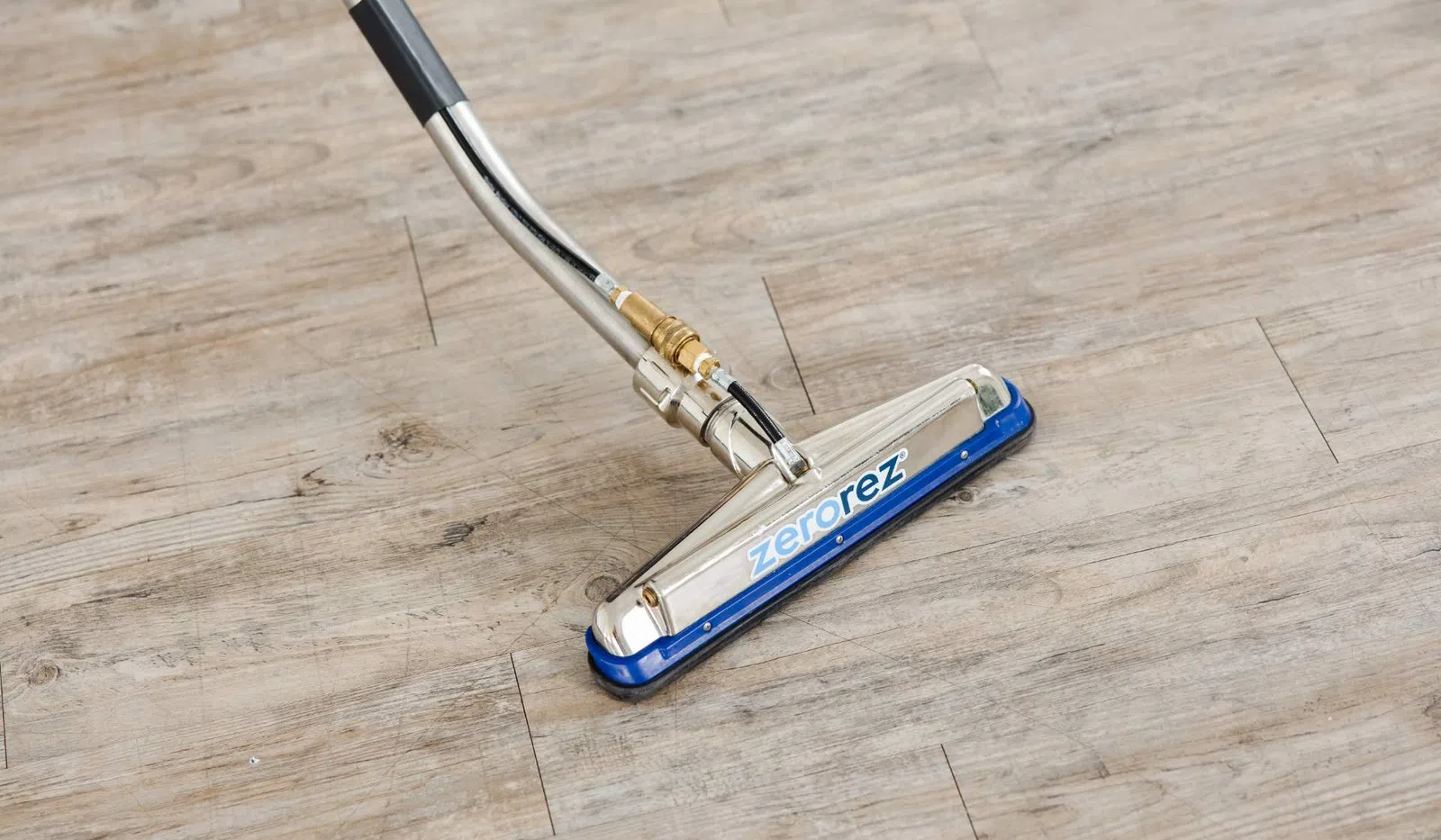 Professional Zerorez carpet cleaning wand on hardwood floor during cleaning process.