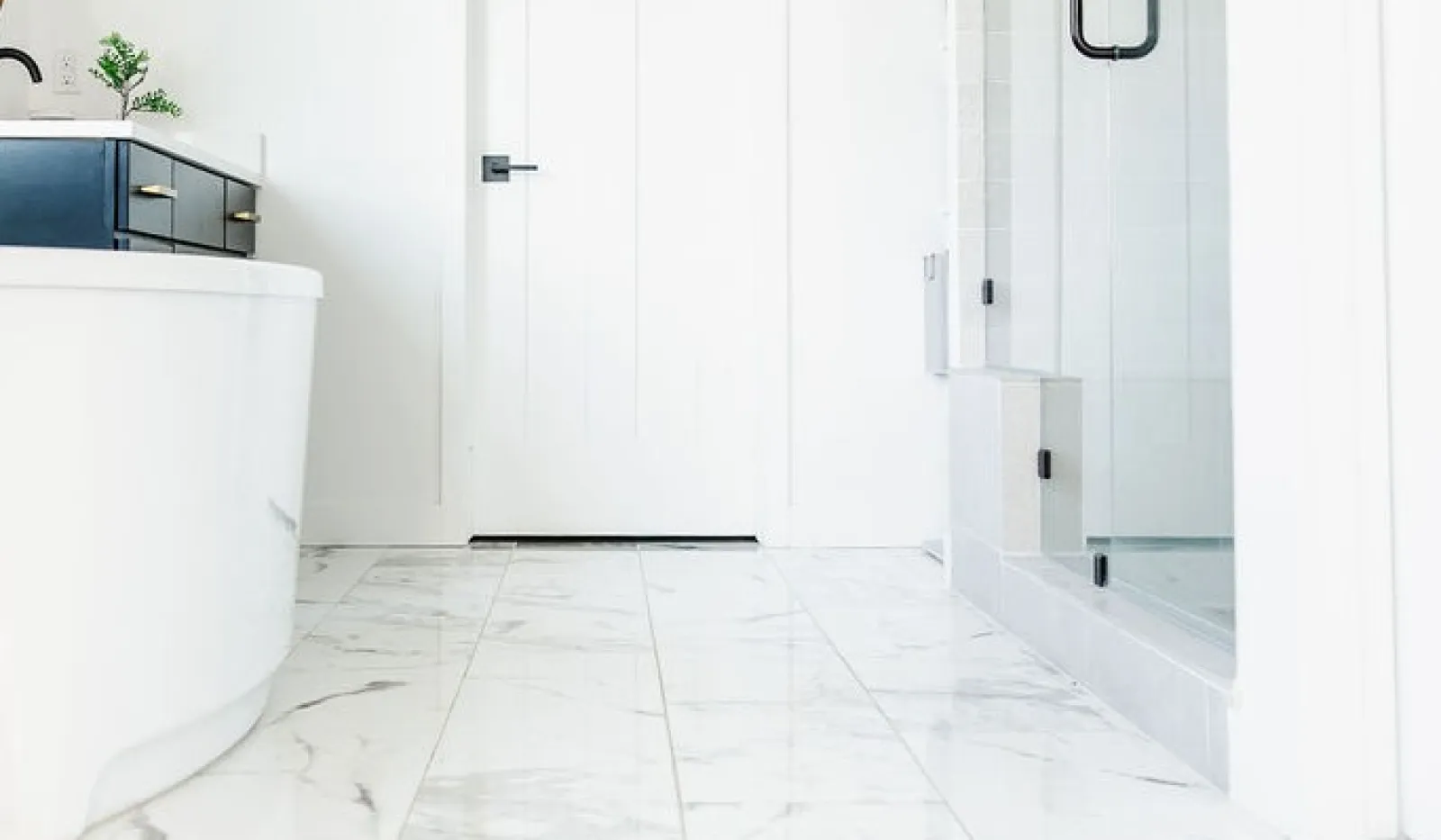 Modern bathroom design featuring a freestanding tub, marble floor, and glass shower enclosure.