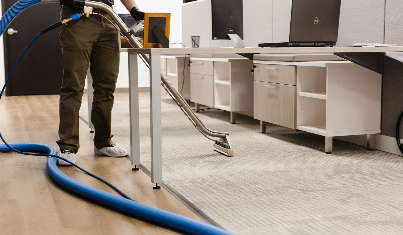 Professional carpet cleaning in an office environment with equipment and spotless floors.