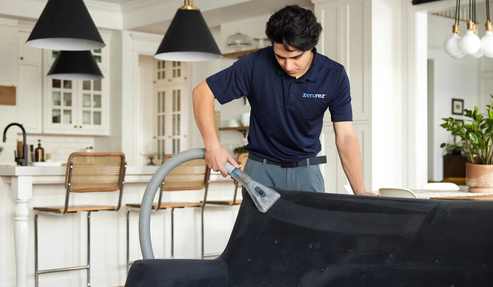 Professional carpet cleaning in a modern living space with stylish decor and a focused technician.