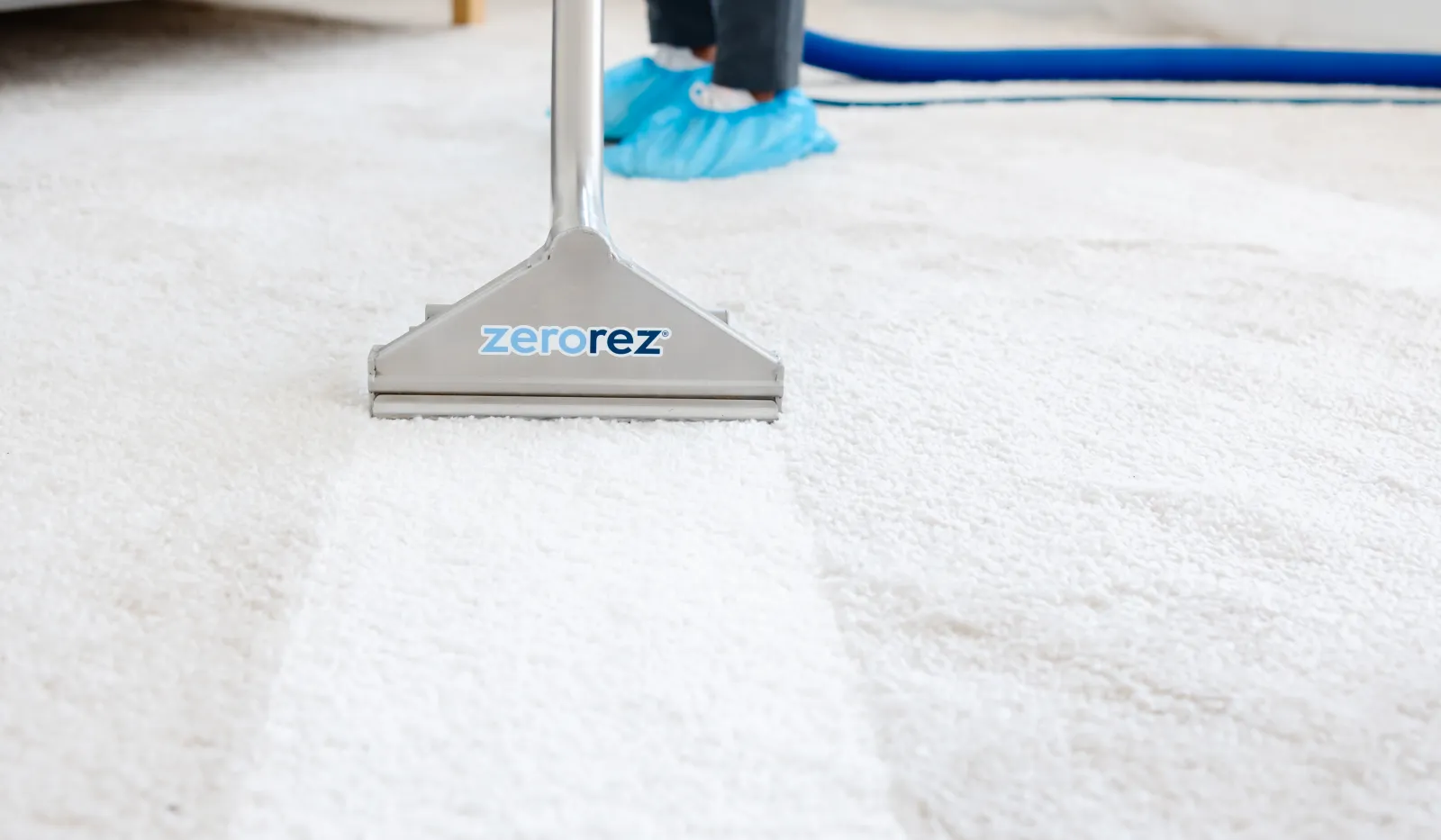 Professional carpet cleaning with Zerorez machine showing clean white carpet and technician