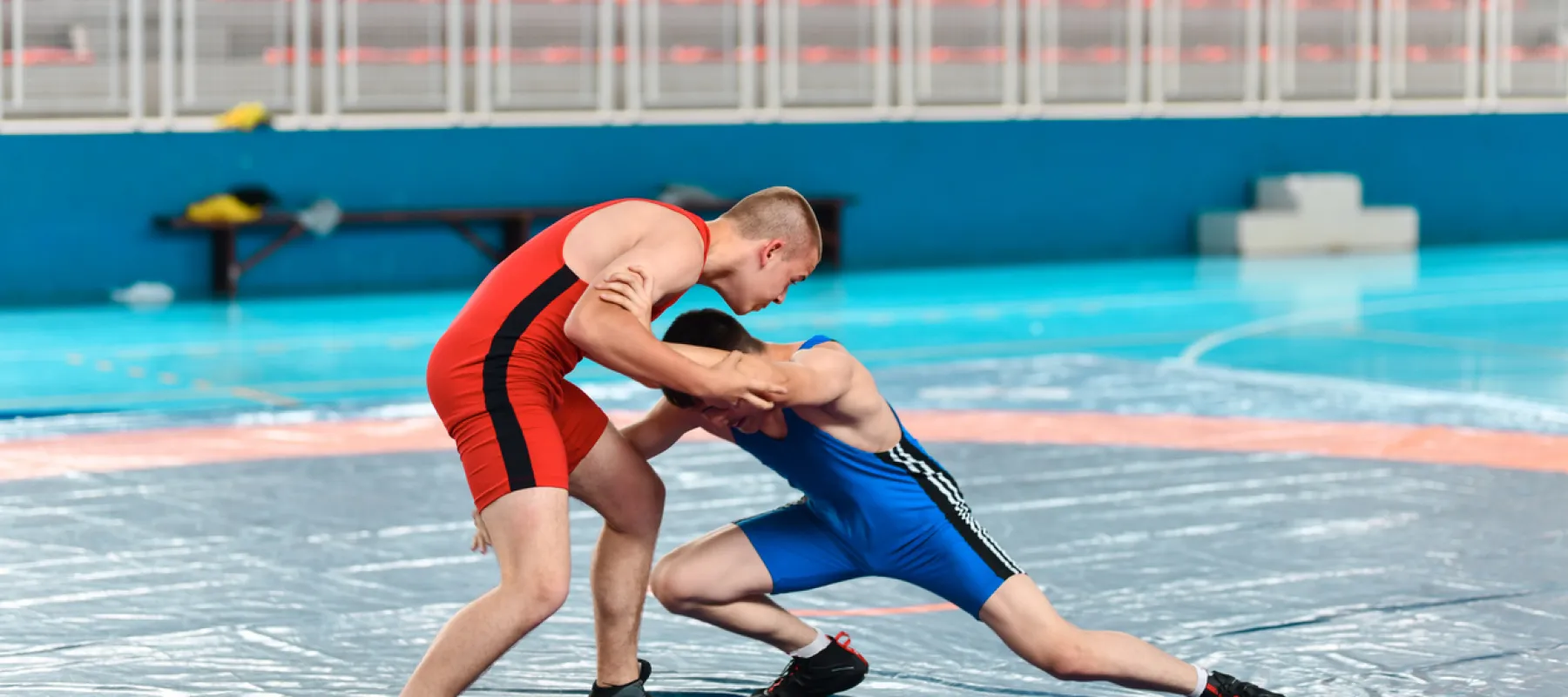 two young men wrestling on a mat