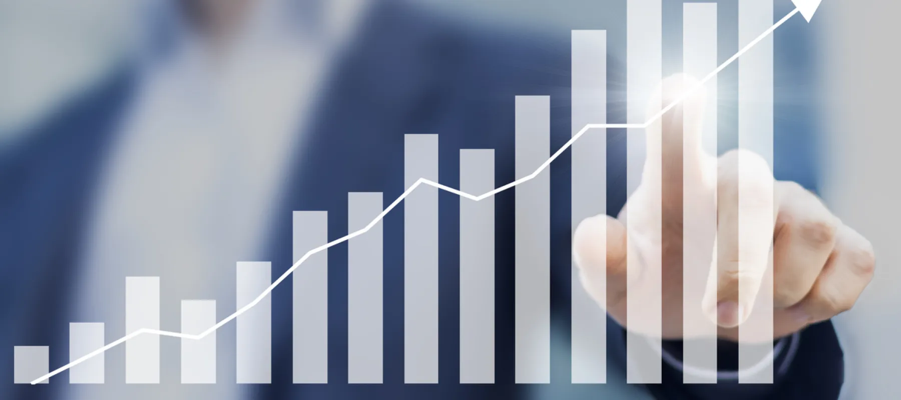 Businessman pointing at an upward trending bar graph symbolizing growth and success