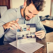 A salesman sitting at a desk and showing a tri-fold brochure