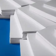 Stacks of large paper sheets lying on a blue surface