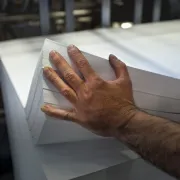 A male hand separating a large stack of paper sheets
