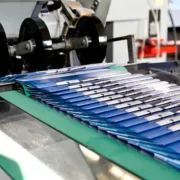 Newly printed booklets exiting the binding machine