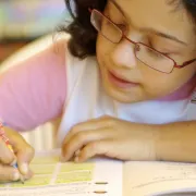 Young female student writes in a workbook