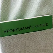 A small green and black guide book protruding from a shirt pocket