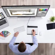 A male graphic designer using computer software to lay out artwork