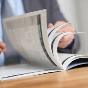A person flipping through a Saddle Stitched Booklet