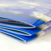 A stack of Saddle-Stitched books with Gloss UV Coating on the covers