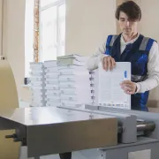 A print shop worker binding a short run of books