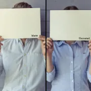 A man and a woman holding up one sheet of paper each