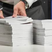 A man inspecting two stacks of Perfect Bound books