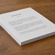 Stack of printed pages titled Foreword placed on wooden surface with readable text about publishing and reflection.