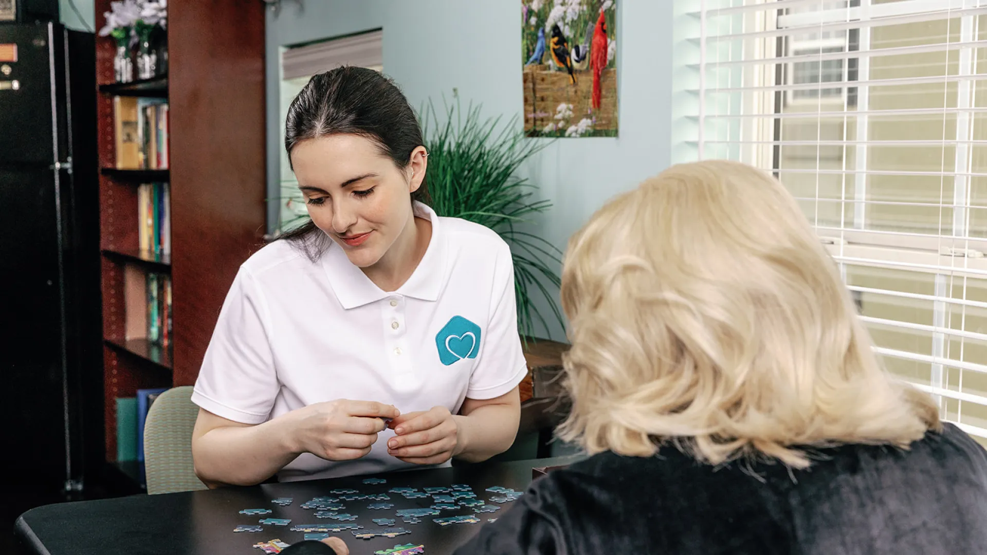 a caregiver and client putting together a puzzle