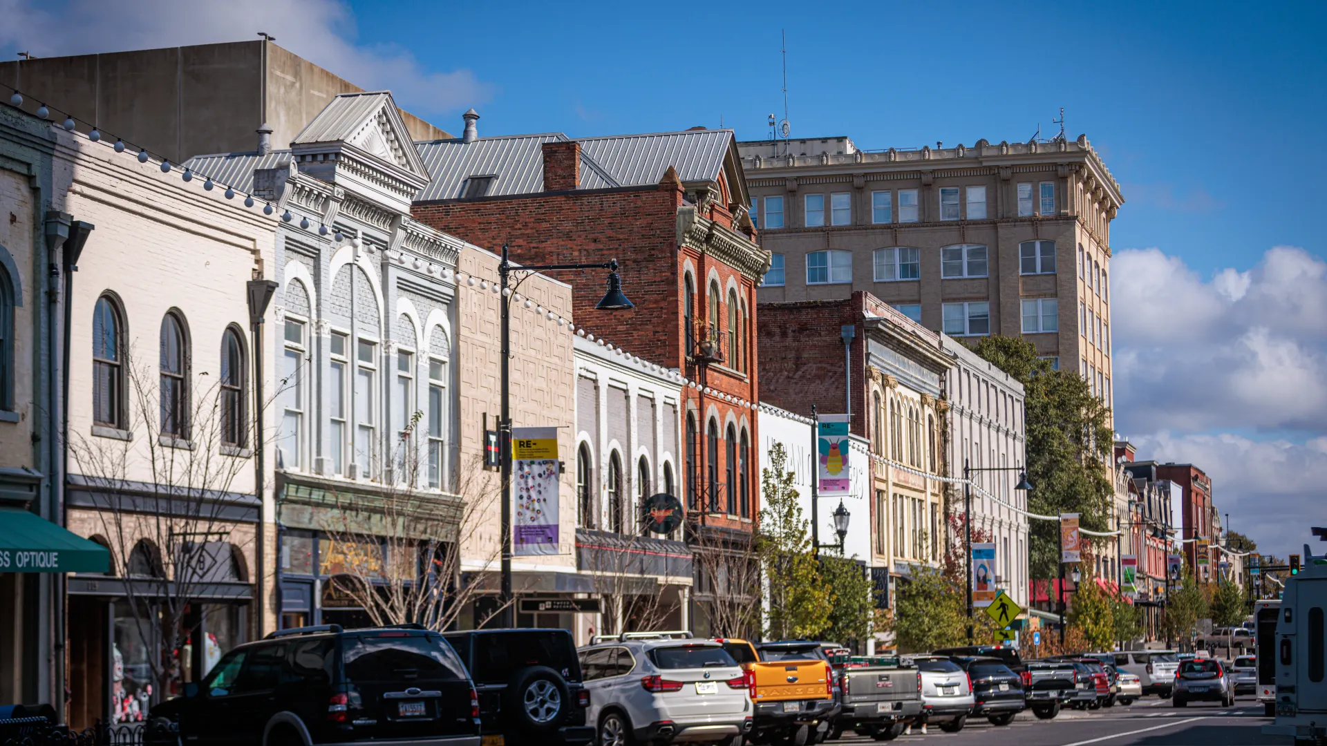 Historic downtown street with vintage buildings, parked cars, and clear blue sky on a sunny day