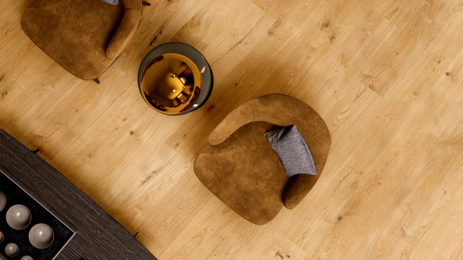 Top view of two brown armchairs with gray pillows and a modern golden side table on wooden floor.