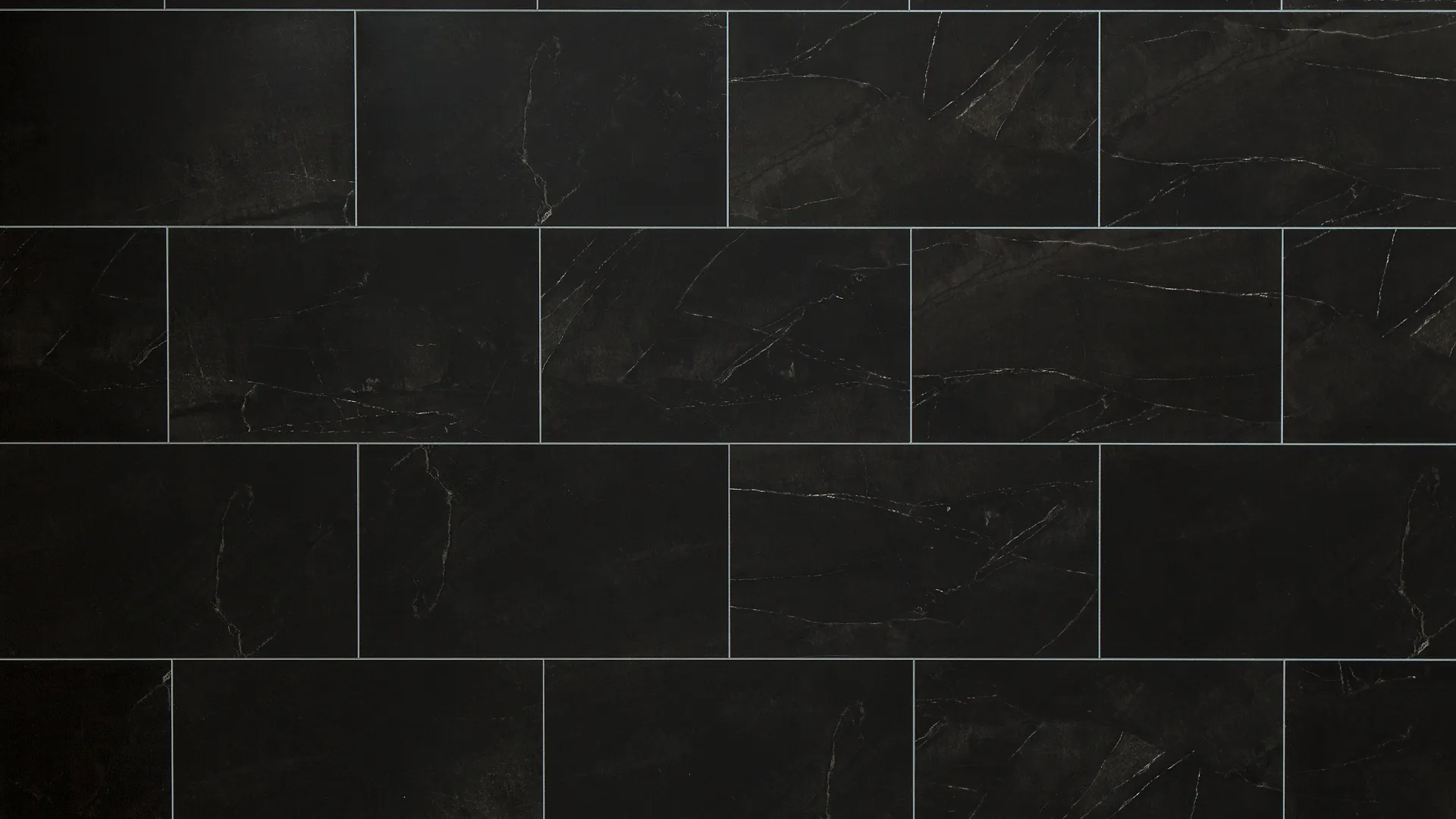 Dark black rectangular tiles with subtle white veining arranged in a staggered brick pattern.