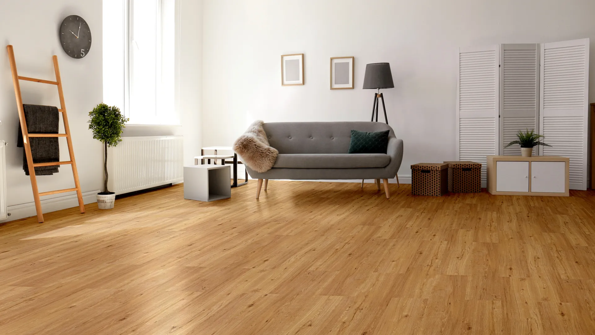 Modern living room with wooden floor, gray sofa, floor lamp, ladder shelf, and minimalist decor and plants