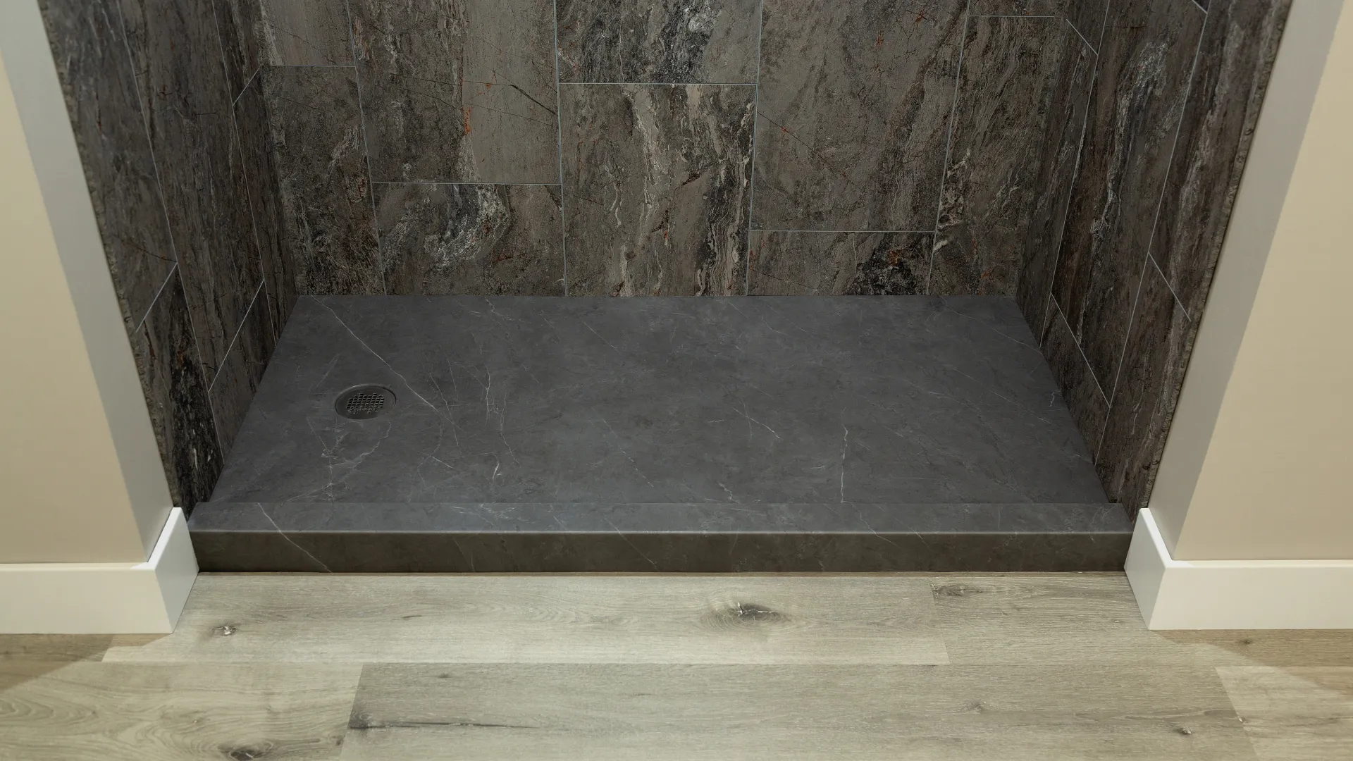 Modern shower area with dark grey stone shower pan and textured brown marble wall tiles, adjacent to light wood flooring.