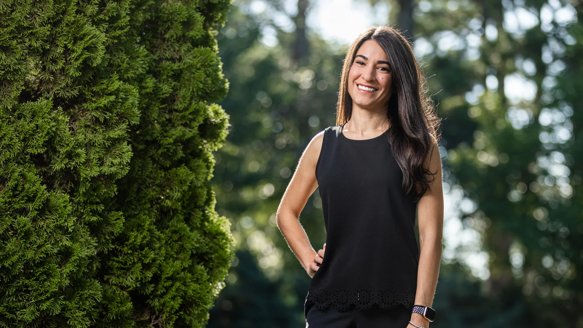 a woman standing next to a tree