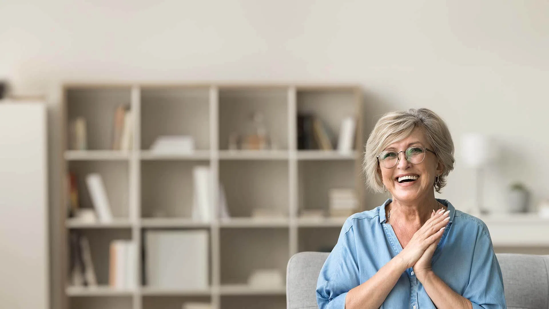 Smiling couple enjoying coffee while looking at a tablet together in a bright modern living room.