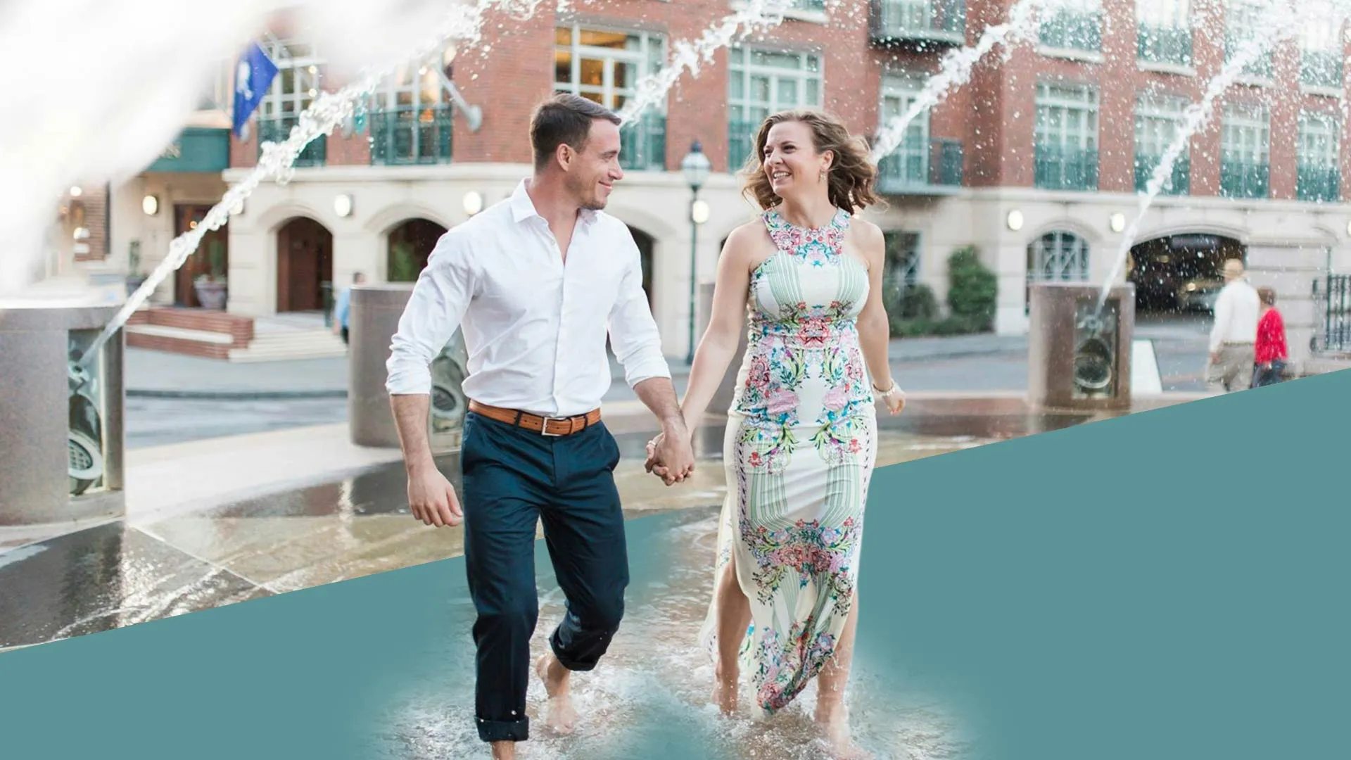 a man and woman walking on a bridge over a pool