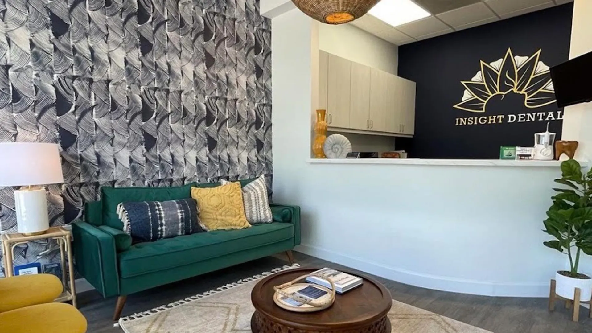 Dental office interior featuring a cozy green sofa and a welcoming reception area with modern decor.