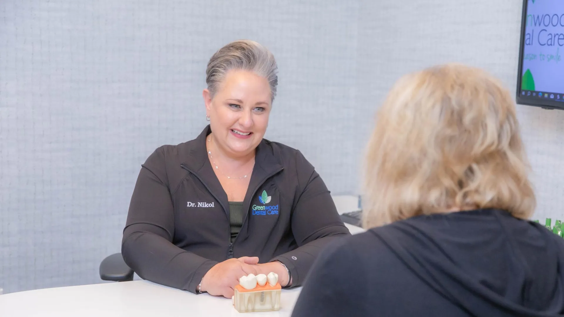 Dentist discussing dental implants with patient in a modern clinic setting