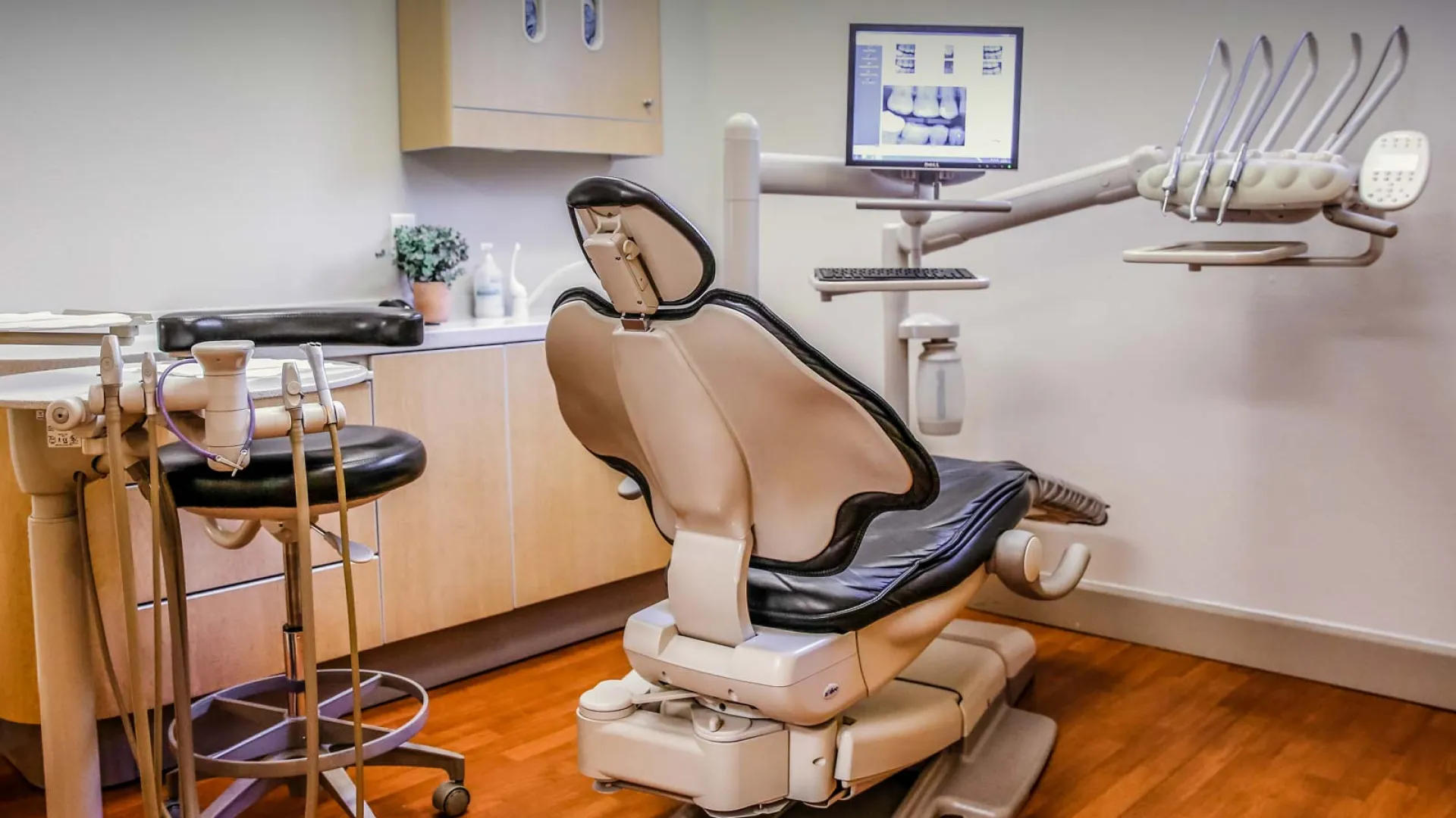 Modern dental office with a chair, tools, and computer ready for patient treatment.