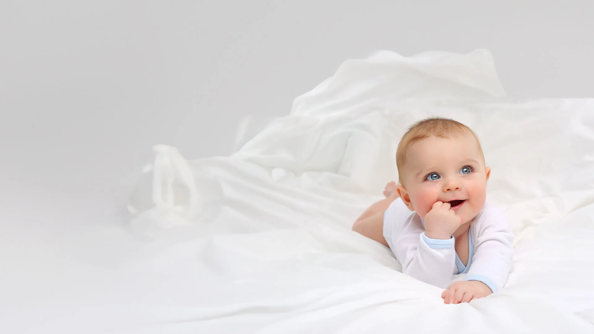 a baby lying on a bed