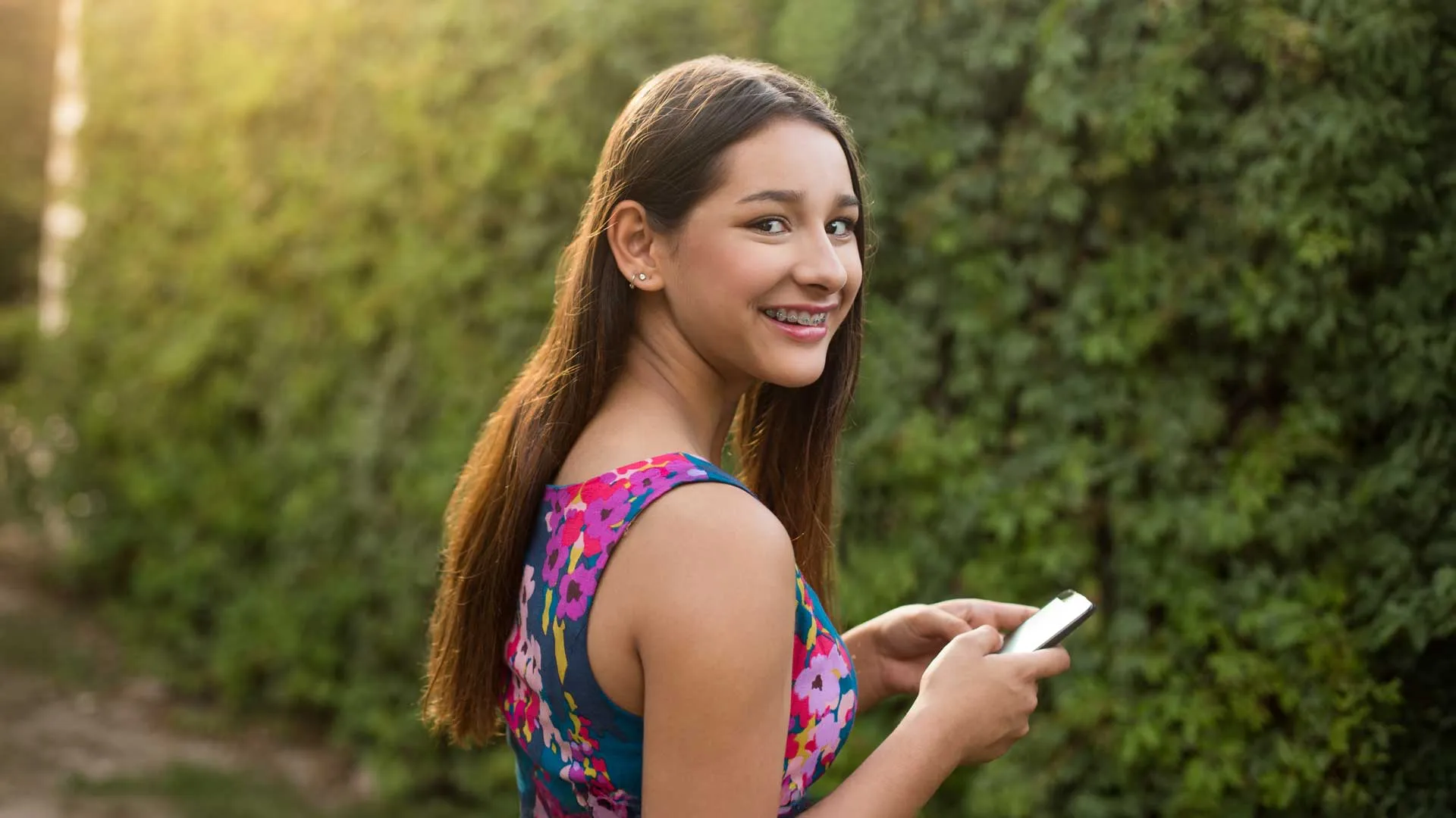 a person smiling and holding a phone
