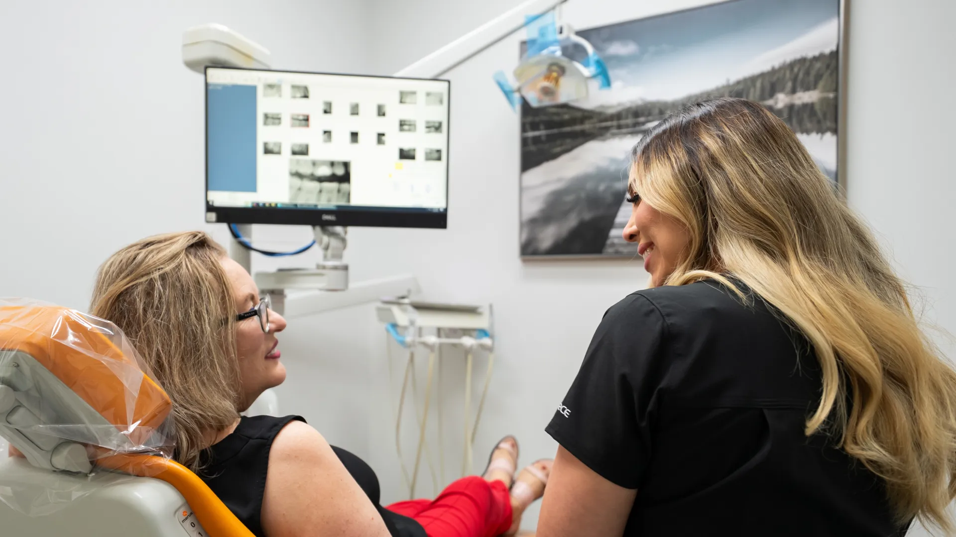 Dentist reviewing dental X-rays with female patient in a modern dental clinic room